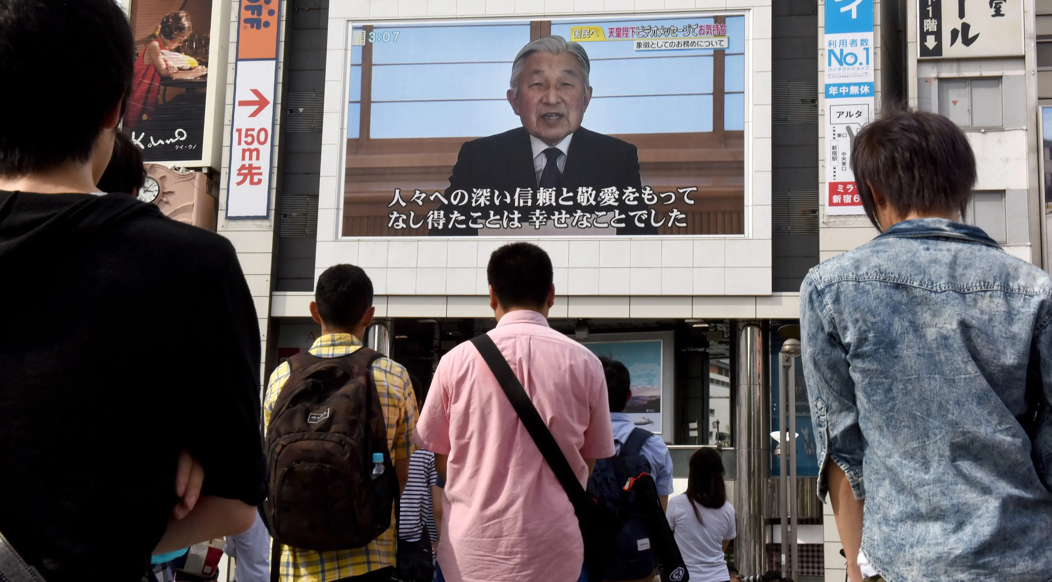 Warga menyaksikan video pidato Kaisar Akihito di Tokyo, Jepang, (8/8). Kaisar mengungkapkan keinginannya untuk turun tahta karena faktor kesehatan dan kekhawatiran dirinya tidak mampu melaksanakan tugas Kekaisaran secara penuh. (AFP PHOTO/Toru Yamanaka)