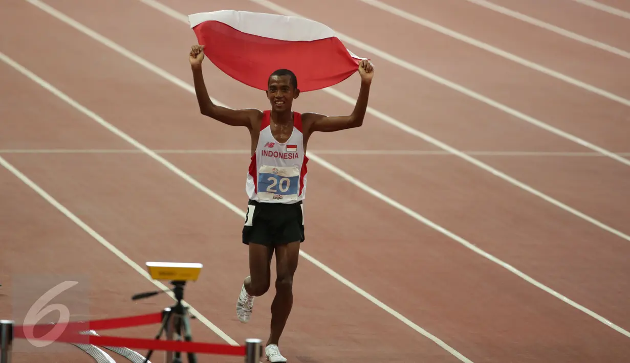 Pelari Indonesia, Agus Prayogo melakukan victory lap sambil mengibarkan sang Merah Putih saat merayakan kemenangannya di nomor lari 10.000 m putra SEA Games 2015 di National Stadium, Singapura, Rabu (10/6/2015). (Liputan6.com/Helmi Fithriansyah)
