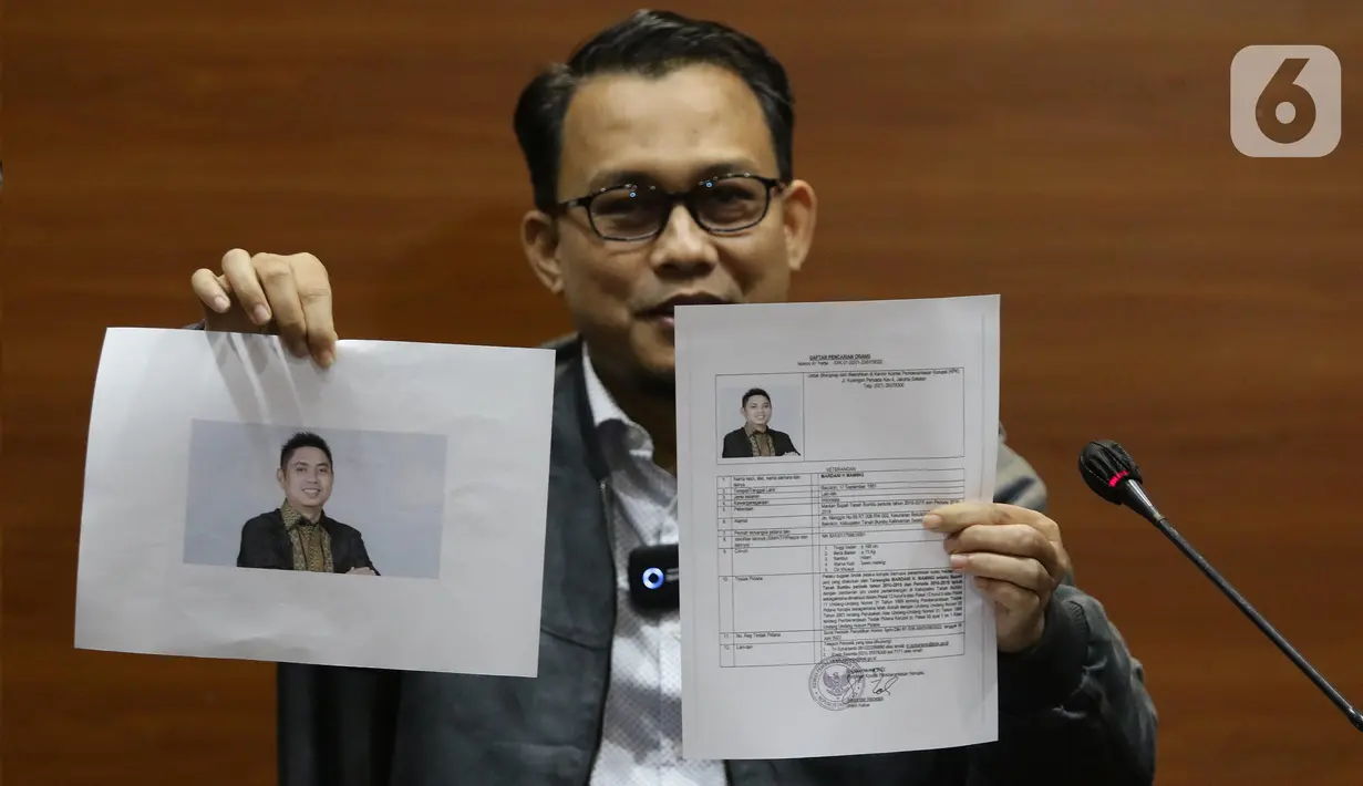 Pelaksana tugas (Plt) Juru Bicara KPK, Ali Fikri menunjukkan data diri Bupati Tanah Bumbu periode 2010-2015 dan 2016-2018, Mardani H. Maming saat mengumumkan status Daftar Pencarian Orang (DPO), Gedung KPK, Jakarta, Selasa (26/7/2022). KPK menetapkan politikus Partai Demokrasi Indonesia Perjuangan (PDI-P) Mardani H Maming masuk dalam Daftar Pencarian Orang (DPO) atau buronan. (Liputan6.com/Helmi Fithriansyah)