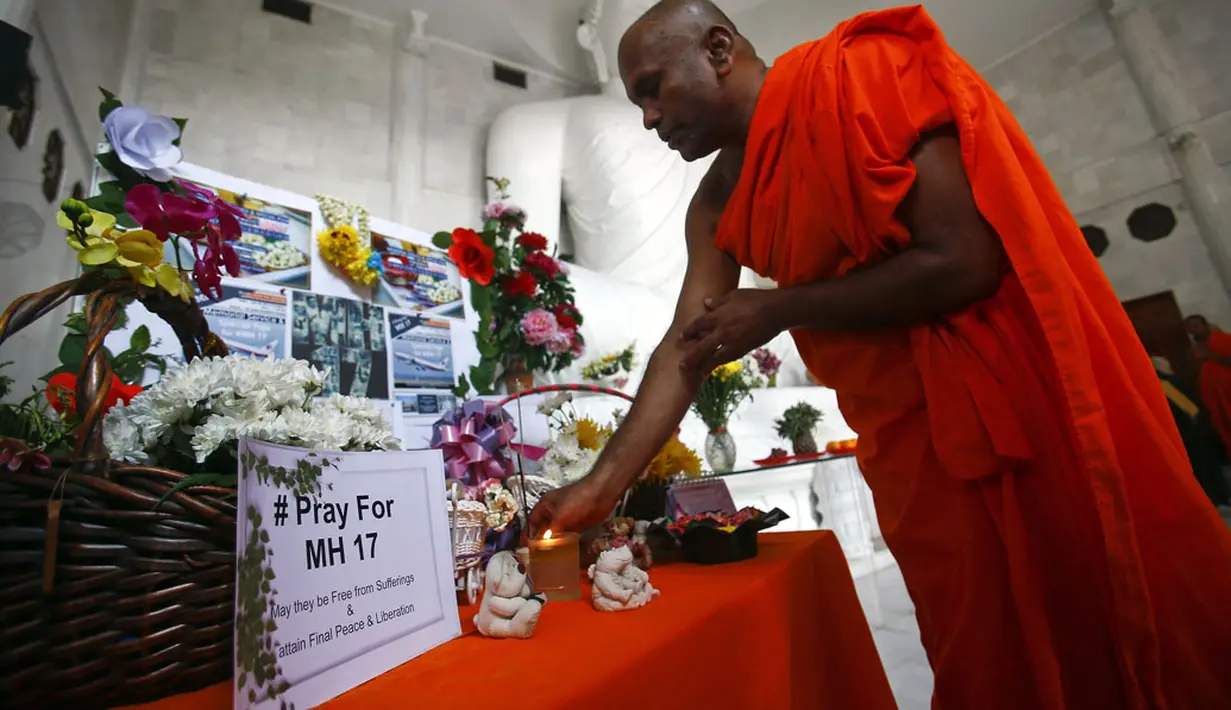 Di sebuah kuil Budha di Kuala Lumpur, seorang biksu memanjatkan doa buat para korban jatuhnya pesawat Malaysia Airlines MH-17, (20/7/2014). (REUTERS/Samsul Said)