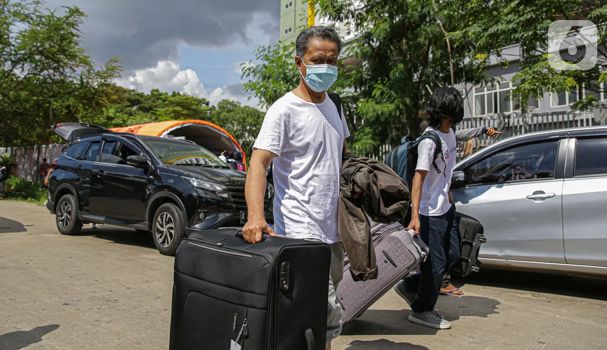 Warga negara Indonesia (WNI) membawa koper mereka usai menjalani isolasi di RSDC Wisma Atlet Pademangan, Jakarta, Selasa (15/6/2021). Pemerintah mewajibkan WNI yang baru tiba di Indonesia untuk melakukan isolasi selama lima hari guna menghindari penularan COVID-19. (Liputan6.com/Faizal Fanani)