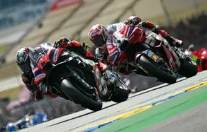 Pembalap Aprilia Racing asal Italia, Marco Bezzecchi (kiri), memimpin pembalap Ducati Lenovo Team asal Italia, Francesco Bagnaia (kanan), selama balapan Sprint Grand Prix MotoGP Prancis di Le Mans, Prancis barat laut, pada 9 Mei 2026. (Loic VENANCE/AFP)