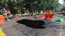 Pengendara melintas di sisi ruas jalan yang ditutup sebagian akibat amblas di Jalan Raya Lenteng Agung, Jakarta Selatan, Jumat (29/5/2026). (merdeka.com/Arie Basuki)