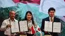 Direktur iZoo Jepang Tuyoshi Shirawa (kanan), Direktur Operasi dan Urusan Umum Kebun Binatang Surabaya Nurika Widyasa (tengah), dan Direktur Keuangan dan Sumber Daya Manusia (SDM) Kebun Binatang Surabaya, Moch. Nahroni memperlihatkan nota kesepahaman yang telah ditandatangani mengenai kerja sama dalam perlindungan dan konservasi satwa liar antara Indonesia dan Jepang di Kebun Binatang Surabaya, Jawa Timur, pada Rabu 29 April 2026. (JUNI KRISWANTO/AFP)