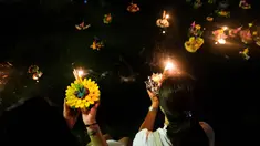 Dua wanita Thailand bersiap menghayutkan 'krathong' untuk merayakan festival Loy Krathong di sebuah danau di Bangkok, Kamis (22/11). Loy Krathong adalah ritual melarung wadah berbentuk lotus yang didalamnya diberi sesajen, lilin dan dupa (Jewel SAMAD/AFP)