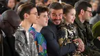 David Beckham bersama anak-anaknya Romeo Beckham, Cruz Beckham dan Harper saat menghadiri peragaan busana Musim Gugur/Musim Dingin 2020 Victoria Beckham dalam acara London Fashion Week di London, (16/2/2020). Beckham tampil dengan setelan jas hitam. (AFP/Daniel Leal-Olivas)