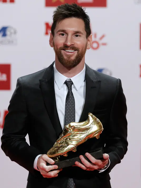 Penyerang Barcelona, Lionel Messi tersenyum usai meraih sepatu emas di Barcelona, Spanyol (24/11). Messi berhasil meraih sepatu emas keempat seperti yang diraih Cristiano Ronaldo. (AP Photo/Manu Fernandez)