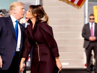 Presiden Trump dan Melania berciuman setelah melewati barisan tentara di Pangkalan Udara Osan, Pyeongtaek, Korea Selatan, (7/11). Trump melakukan kunjungan ke lima negara Asia Jepang, Korea Selatan, China, Vietnam dan Filipina. (AP Photo / Andrew Harnik)
