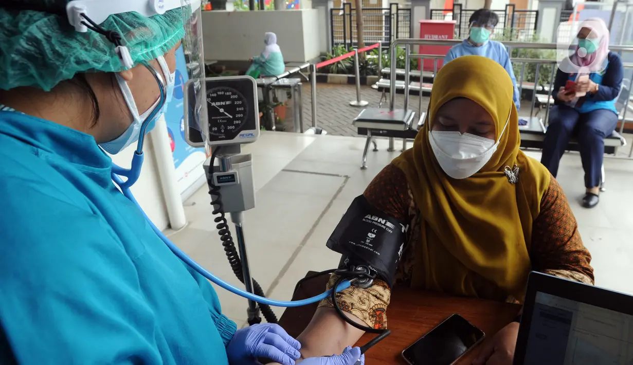 Dokter memeriksa kondisi seorang wanita sebelum melakukan vaksinasi virus corona COVID-19 produksi Sinovac di Puskemas Jagakarsa, Jakarta Selatan, Kamis (14/1/2020). Sejumlah Puskesmas di Jabodetabek mulai melakukan vaksinasi COVID-19 pada hari ini. (merdeka.com/Arie Basuki)