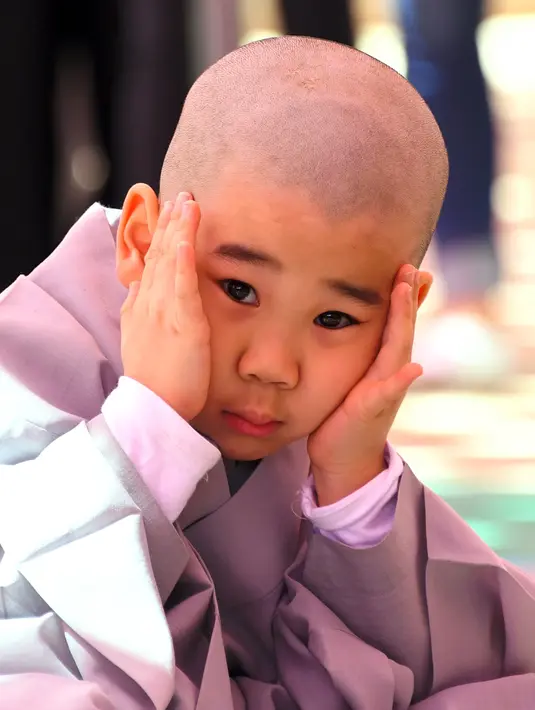 Anak-anak yang mengikuti upacara ini disuruh tinggal di kuil selama dua minggu dan diajarkan tentang Buddhisme di kuil Jogye, Seoul, Rabu (19/4). (AFP PHOTO / JUNG Yeon-Je)