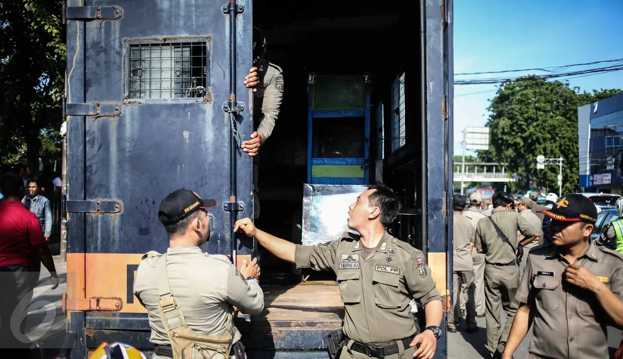 Petugas menyita gerobak pedagang dalam penertipan PKL di kawasan Stasiun Kota Tua, Jakarta, Selasa (25/10). Dalam penertipan tersebut pedagang melawan dikarenakan mereka telah membayar iuran setiap harinya  ke petugas. (Liputan6.com/Faizal Fanani)