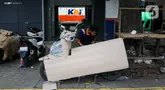 Pekerja mengemas motor untuk dikirim melalui salah satu jasa pengiriman logistik di kawasan Pasar Senen, Jakarta, Minggu (23/3/2025). (Liputan6.com/Herman Zakharia)