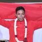 Pelari muda Indonesia, Lalu Muhammad Zohri membentangkan bendera Merah Putih saat penyambutan di Terminal 3 Bandara Soetta, Tangerang, Selasa (17/7). Lalu M Zohri meraih emas 100m putra di Kejuaraan Dunia Atletik U-20. (Liputan6.com/Helmi Fithriansyah)