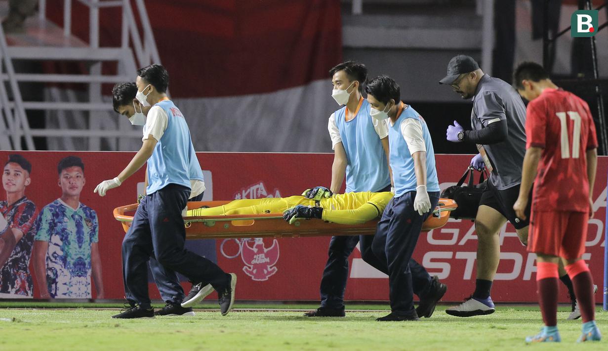 Kiper Timnas Indonesia U-20, Cahya Supriadi ditandu keluar lapangan menuju ambulans usai mengalami cedera dalam pertandingan matchday kedua Kualifikasi Grup F Piala Asia U-20 2023 di Stadion Gelora Bung Tomo, Surabaya, Jumat (16/9/2022). (Bola.com/Ikhwan Yanuar)