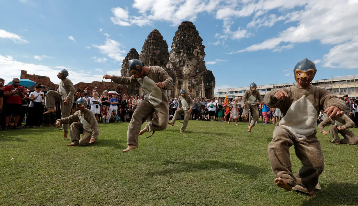 Penari dengan kostum monyet menari di hadapan wisatawan selama Festival Monkey Buffet, kuil Phra Prang Sam Yot, Bangkok, Thailand (27/11). Festival ini juga menampilkan berbagai kesenian dan budaya. (REUTERS/Chaiwat Subprasom)