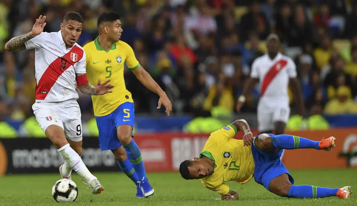 Bek Brasil, Alex Sandro, dijatuhkan striker Peru, Paolo Guerrero, pada laga final Copa America 2019 di Stadion Maracana, Rio de Janeiro, Minggu (7/7). Brasil menang 3-1 atas Peru. (AFP/Pedro Ugarte)
