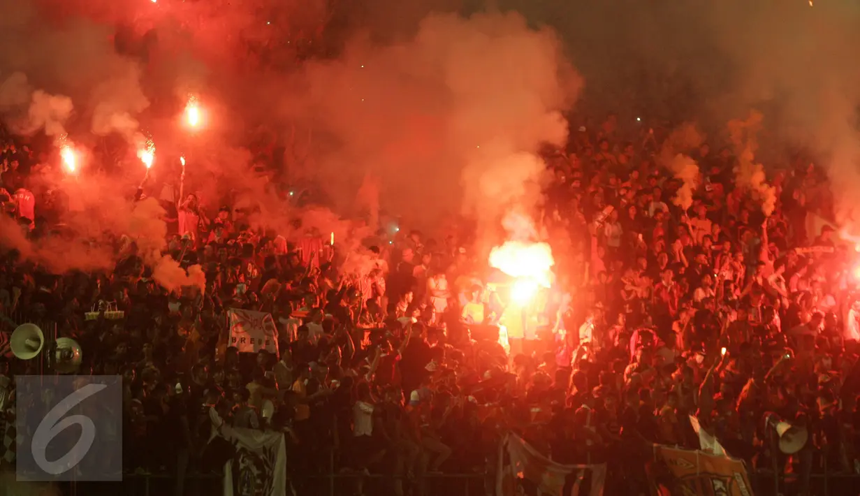 Suporter Persija membakar kembang api pada pertandingan 8 besar Piala Jendral Sudirman antara Persija vs Semen Padang di Stadion Manahan Solo, Minggu (20/12). Skor akhir 6-5 untuk Persija, namun tetap tak lolos ke babak semifinal. (Boy Harjanto)