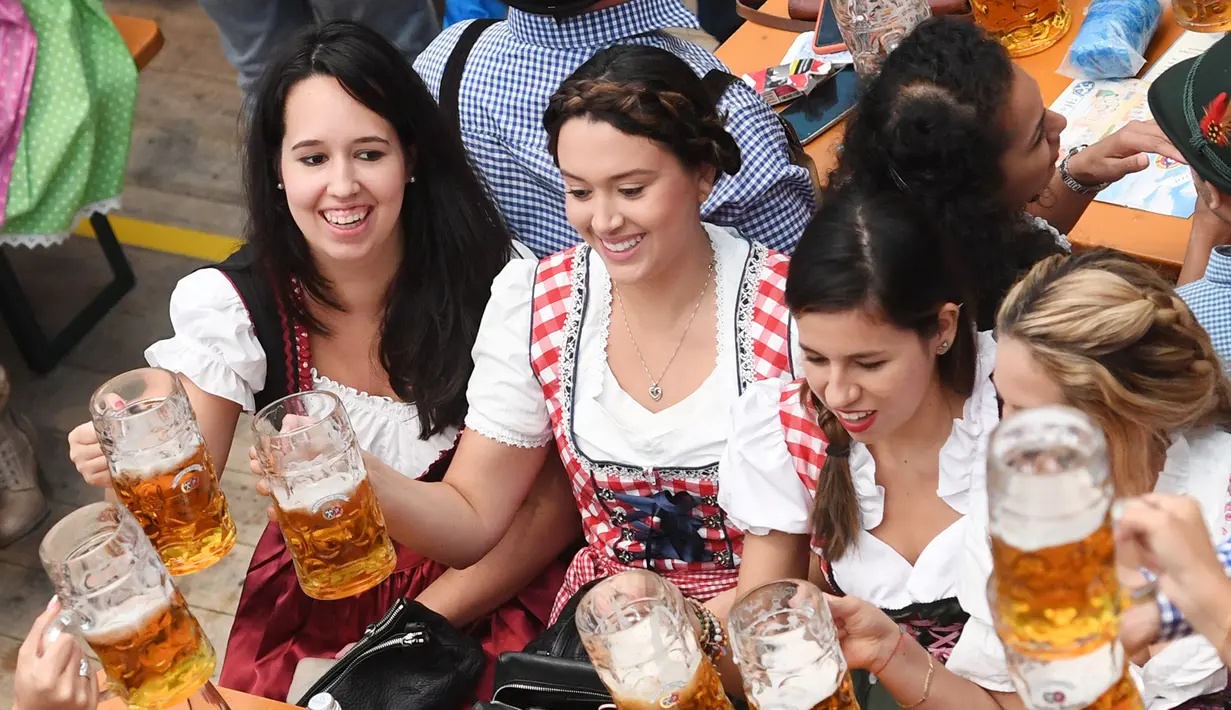 Sejumlah wanita bersulang dengan gelas berisi bir saat mengikuti festival minum bir tahunan dalam pembukaan Oktoberfest ke-182 di Munich, Jerman (16/9). Festival ini diadakan dari tanggal 16 sampai 3 Oktober 2017. (AFP Photo/dpa/Tobias Hase/Germany Out)