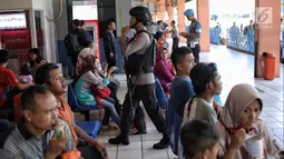 Pasukan Brimob Polda Metro Jaya bersenjata berjalan di antara penumpang di Terminal Kampung Rambutan, Jakarta, Selasa (19/6). Penjagaan dilakukan untuk memberi rasa aman kepada pemudik pada arus balik Lebaran 2018. (Liputan6.com/Faizal Fanani)