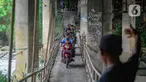 Pengendara sepeda motor melintas jalur alternatif khusus motor pada jembatan yang melintasi Sungai Ciliwung menuju arah Puncak di kawasan Katulampa, Kabupaten Bogor, Jawa Barat, Kamis (11/04/2024). (merdeka.com/Arie Basuki)