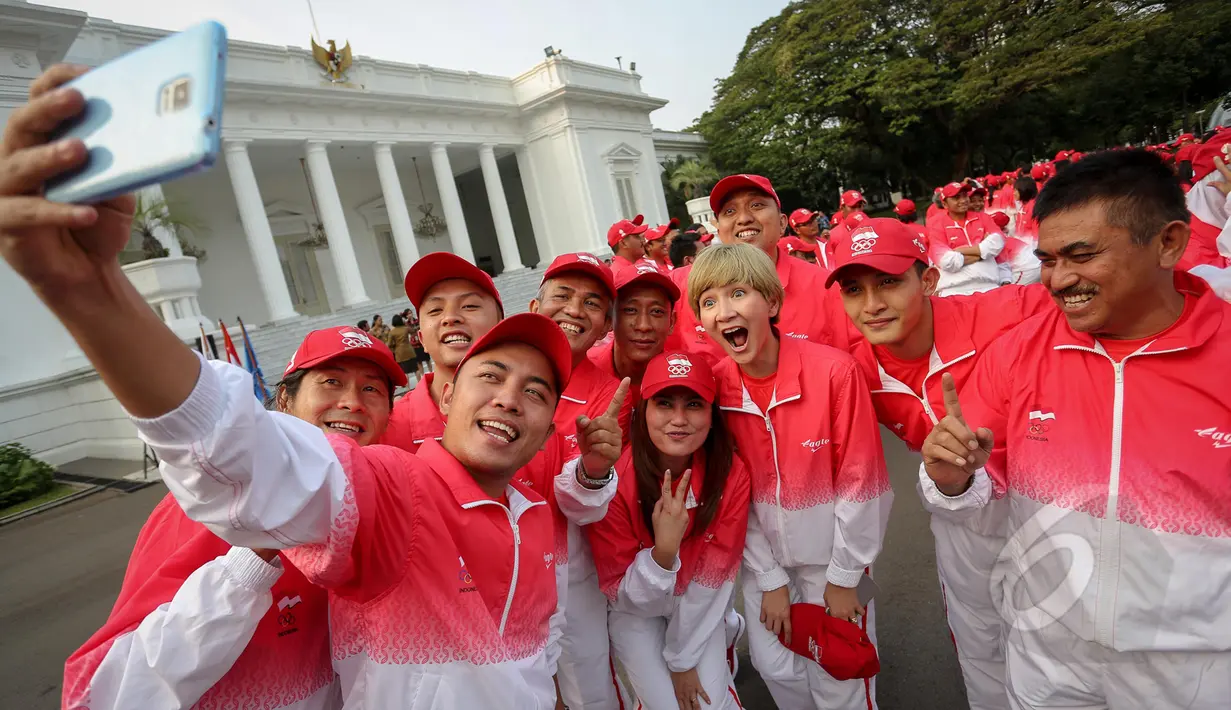 Sejumlah atlet berselfie saat berada di depan Istana Merdeka sebelum acara pelepasan kontingen sea games di Istana Merdeka, Jakarta, Selasa (26/5/2015). Indonesia menurunkan 522 atlet yang berlaga di 32 cabang olah raga. (Liputan6.com/Faizal Fanani)