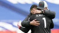 Kiper Liverpool, Alisson Becker, dipeluk oleh Jurgen Klopp usai laga melawan West Bromwich Albion pada laga Liga Inggris di Stadion the Hawthorns, Minggu (16/5/2021). Liverpool menang dengan skor 2-1. (Tim Keeton/Pool via AP)