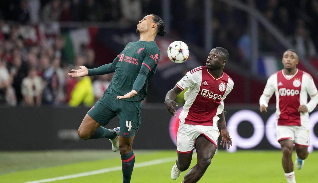Bek Liverpool Virgil van Dijk berebut bola dengan penyerang Ajax Amsterdam Brian Brobbey pada matchday kelima Grup A Liga Champions 2022-2023 di Johan Cruiff Arena,  Kamis (27/10/2022) dini hari WIB. Tiga gol Liverpool yang bersarang ke gawang Ajax dikemas oleh Mohamed Salah, Darwin Nunez, dan Harvey Elliott. (AP Photo/Peter Dejong)