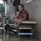 Aktivitas warga saat banjir merendam RT 10/RW 05, Kampung Sawah, Kelurahan Rawa Terate, Cakung, Jakarta Timur, Kamis (20/2/2020). Banjir diperparah dengan adanya pembangunan apartemen di kawasan Kelapa Gading sehingga aliran air tidak lagi mengalir ke laut. (merdeka.com/Iqbal Nugroho)