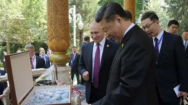 Presiden Rusia Vladimir Putin menghadiahi Presiden China Xi Jinping sekotak besar es krim untuk ultah ke-66 (Sputnik / AFP PHOTO)