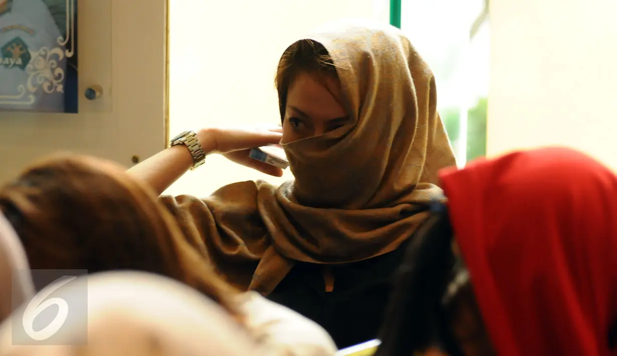 Salah satu warga negara asing illegal yang terjaring operasi pengawasan menutupi wajah saat rilis di Ditjen Imigrasi, Jakarta, Jumat (13/1). Diduga, para WNA tersebut bekerja sebagai pekerja seks komersial (PSK). (Liputan6.com/Helmi Fithriansyah)