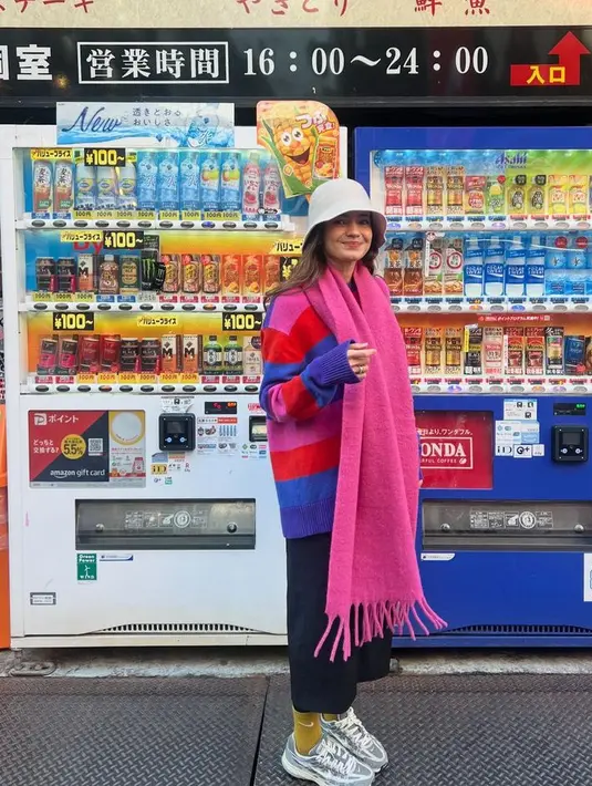 Enzy juga tampil dengan gaya colorful mengenakan sweater oversize dan syal pink dipadukan celana hitamnya. Dilengkapi bucket hat putih. [@enzystoria]