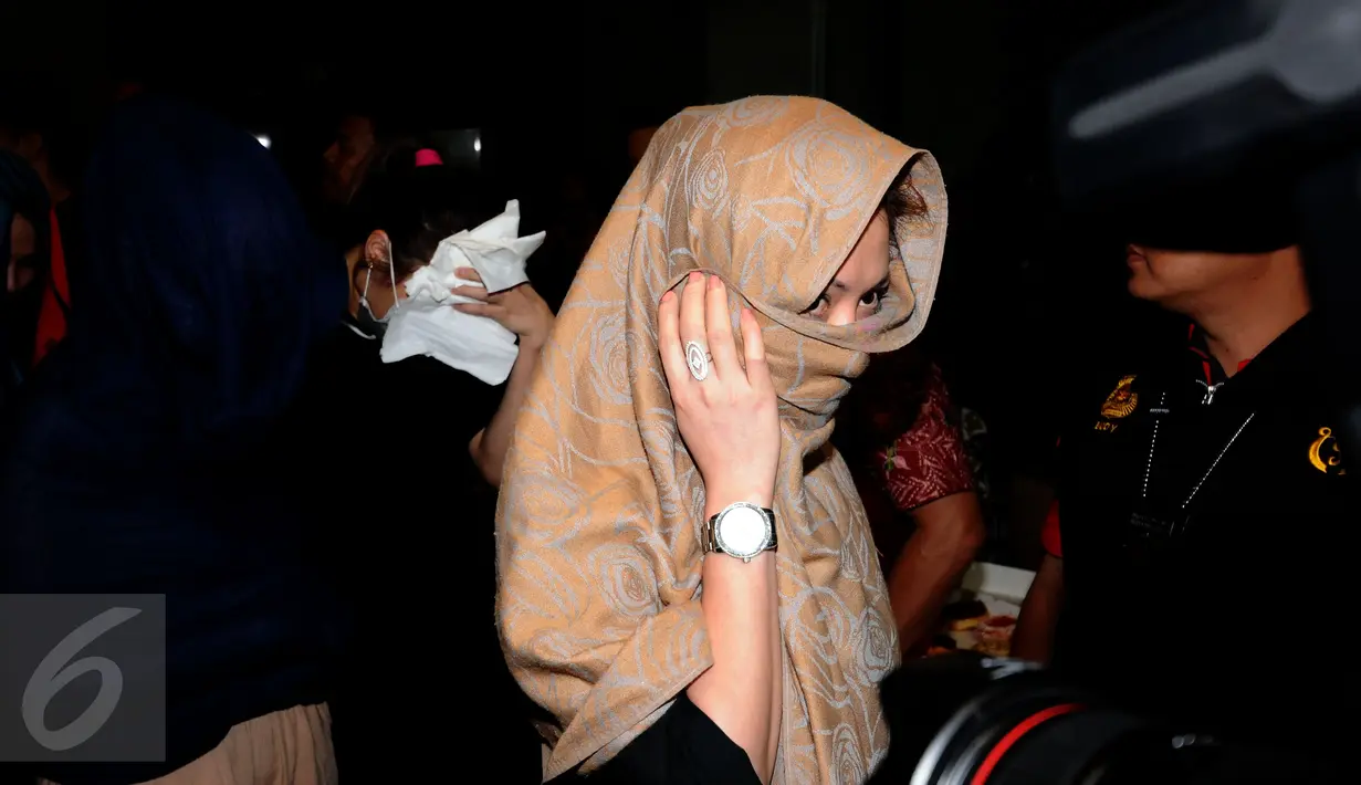 Salah satu warga negara asing illegal yang terjaring operasi pengawasan menutupi wajah saat rilis di Ditjen Imigrasi, Jakarta, Jumat (13/1). Diduga, para WNA tersebut bekerja sebagai pekerja seks komersial (PSK). (Liputan6.com/Helmi Fithriansyah)