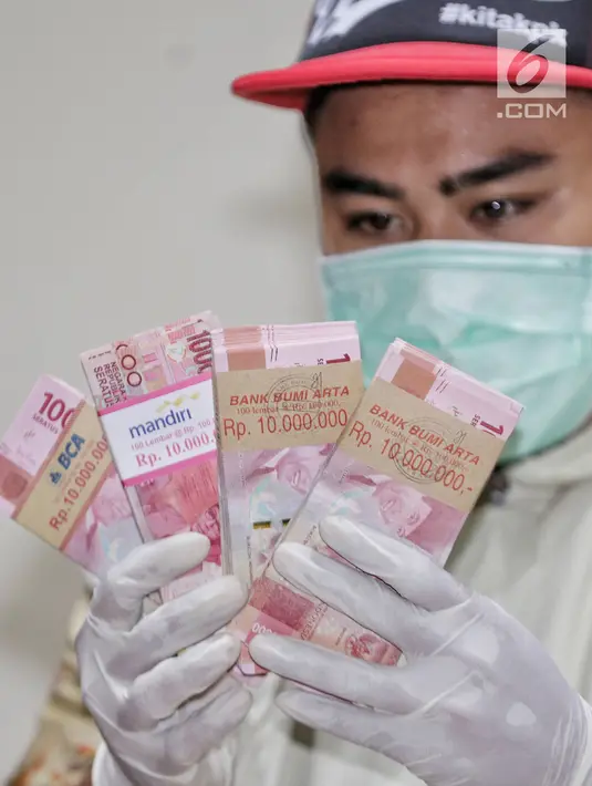 Petugas menunjukkan barang bukti uang hasil OTT terhadap Ketum PPP Romahurmuziy, di gedung KPK, Jakarta, Sabtu (16/3). KPK mengamankan uang total Rp 156 juta dalam operasi tangkap tangan (OTT) di Surabaya pada Jumat (15/3). (Liputan6.com/Faizal Fanani)