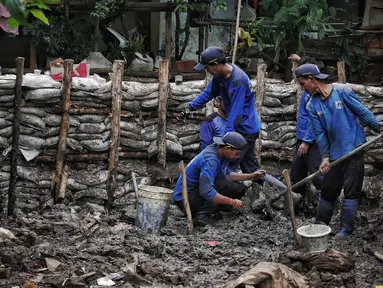 Petugas Suku Dinas SDA Jakarta Selatan membangun turap permanen di lokasi tanggul jebol di Kelurahan Jatipadang, Jakarta, Rabu (16/1). Kasudin SDA Jakarta Selatan Holi Susanto menargetkan pembangunan selesai dalam tiga minggu. (Liputan6.com/Faizal Fanani)