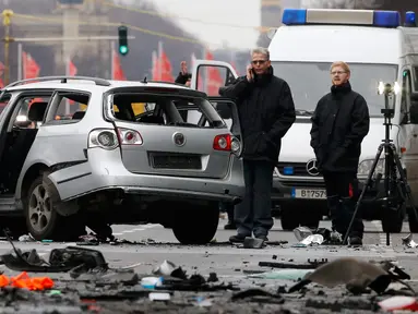 Petugas kepolisian memeriksa bangkai mobil Volkswagen yang rusak di Berlin , Jerman, (15/3). Warga Jerman di gegerkan oleh sebuah mobil yang tiba meledak di pusat kota Berlin. (REUTERS / Fabrizio Bensch)