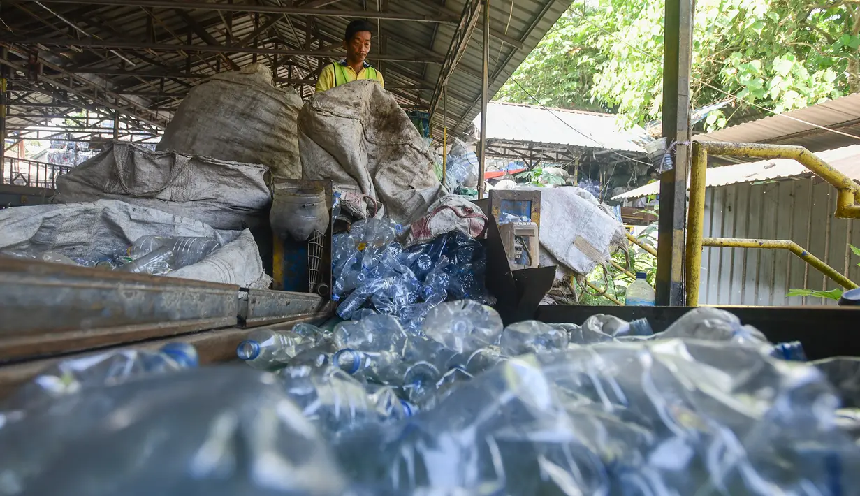 Pekerja mengolah sampah botol kemasan menjadi cacahan sebagai bahan biji plastik di Koperasi Pemulung Berdaya atau Recycle Business Unit (RBU) Tangerang Selatan, Tangerang, Banten, Rabu (30/7/2025). (merdeka.com/Arie Basuki)