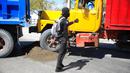 Petugas polisi bersenjata dan bertopeng membuat seorang pengemudi truk memundurkan truknya untuk digunakan sebagai barikade saat protes untuk mengecam tata kelola polisi yang buruk di Port-au-Prince, Haiti,  26 Januari 2023. Kelompok hak asasi manusia Haiti, Jaringan Nasional Pertahanan Hak Asasi Manusia, mengungkapkan bahwa 78 petugas polisi tewas sejak Henry berkuasa pada tahun 2021. (AP Photo/Odelyn Joseph)