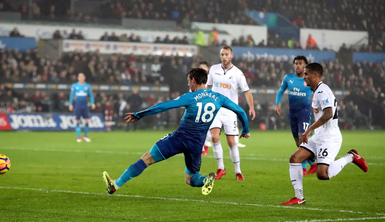 Pemain Arsenal, Nacho Monreal mencetak gol ke gawang Swansea City dalam laga pekan ke-25 Premier League  di Liberty Stadium, Selasa (30/1). Sempat unggul, pemain Swansea memaksa Arsenal tiga kali melihat gawang mereka kebobolan. (Nick Potts/PA via AP)