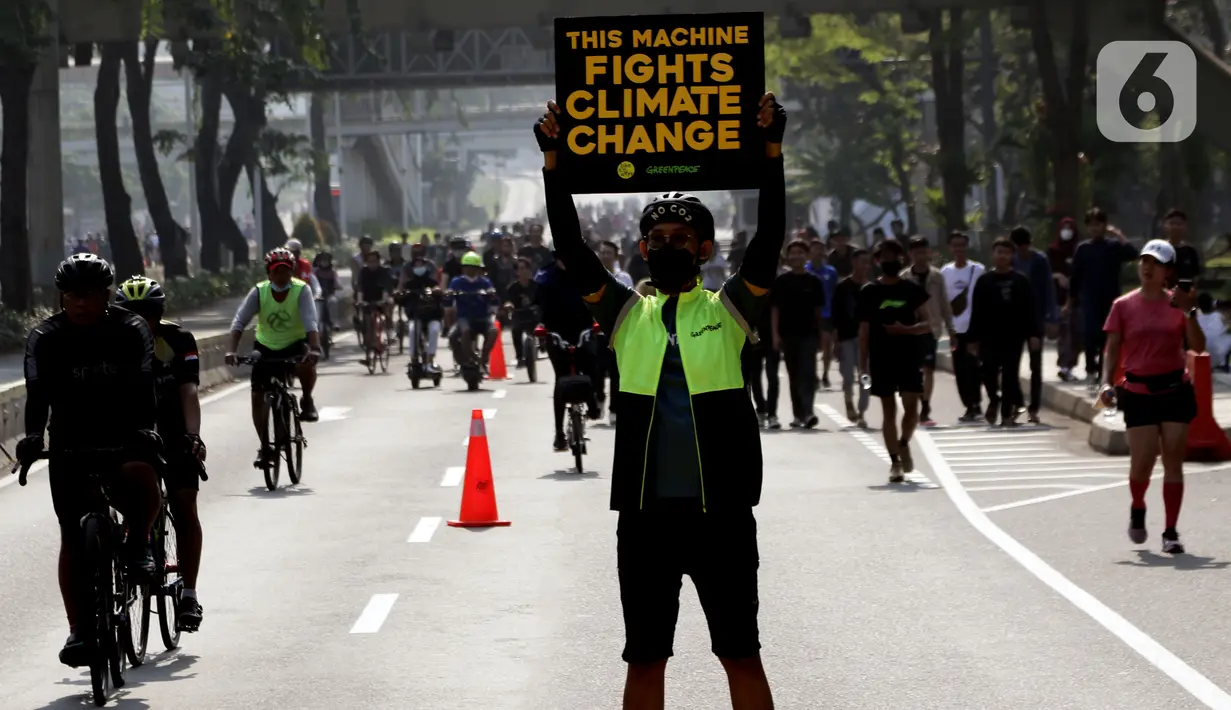 Aktivis Greenpeace dan Bike2Work membentangkan tulisan di Jalan Jenderal Sudirman, Jakarta, Minggu (5/6/2022). Aksi ini untuk memperingati Hari Lingkungan Hidup dan hari Sepeda Sedunia serta kampanye penggunaan sepeda sebagai kendaraan ramah lingkungan. (Liputan6.com/Helmi Fithriansyah)
