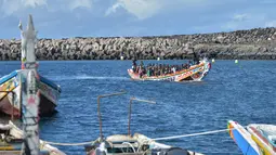 Sekelompok imigran yang kelelahan berjuang untuk menarik diri mereka ke pelabuhan La Restinga, sebuah desa nelayan di pulau kecil El Hierro di kepulauan Canary, Spanyol. (STRINGER / AFP)