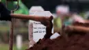 Petugas merapikan makam jenazah dengan protokol COVID-19 di TPU Bambu Apus, Jakarta, Jumat (22/1/2021). Lahan pemakaman khusus dengan luas 3.000 meter persegi di TPU Bambu Apus ini diperkirakan mampu menampung 700 jenazah dengan protokol COVID-19. (Liputan6.com/Helmi Fithriansyah)