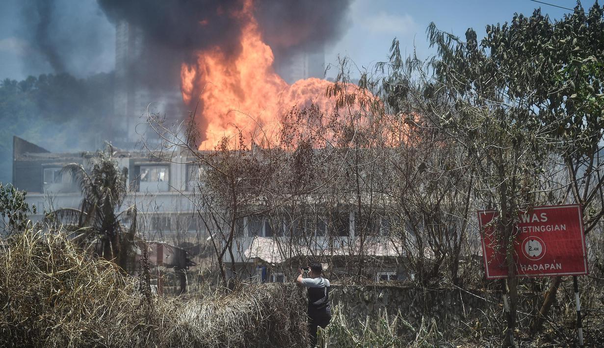 Seorang pria menyaksikan kebakaran yang disebabkan oleh kebocoran pipa gas di Puchong, Selangor, Malaysia pada 1 April 2025. (Arif Kartono/AFP)