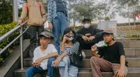 Para remaja dari berbagai daerah di pinggiran Jakarta berpose di Taman Sudirman, Jakarta, Rabu (6/7/2022). Tempat ini viral karena jadi ajang adu fashion anak Citayam, Bekasi hingga Bojong Gede. Mereka mengenakan kemeja flanel oversize, celana model 90-an seperti boot cut atau cutbray, sneakers klasik, dan topi. (Liputan6.com/Faizal Fanani)