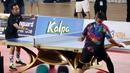 Denny Cagur (kiri) memakai kostum unik saat bertanding tenis meja melawan Cing Abdel di Turnamen Olahraga Selebriti Indonesia yang berlangsung di GOR Universitas Negeri Jakarta, Sabtu (29/7/2023).  Denny Cagur terlihat memakai kaos kaki berwarna putih dengan logo ayam jago yang biasa digunakan di mangkok. (Bola.com/Abdul Aziz)