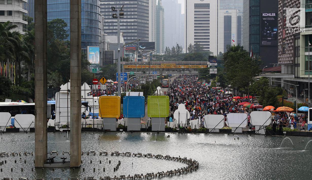 Warga memadati Jalan Jendral Sudirman dan MH Thamrin saat pelaksanaan car free day (CFD) di Jakarta, Minggu (11/2). Meski sempat diguyur hujan, warga tetap antusias beraktivitas. (Liputan6.com/Immanuel Antonius)