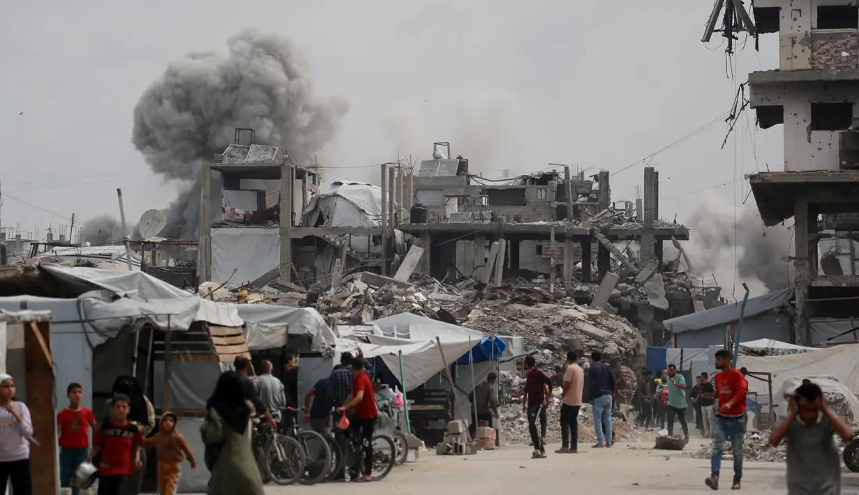 Warga Palestina berlarian menyelamatkan diri saat serangan Israel menghantam rumah keluarga Hmeid di Jabalia, Jalur Gaza Utara, 15 Mei 2025. (Bashar TALEB/AFP)