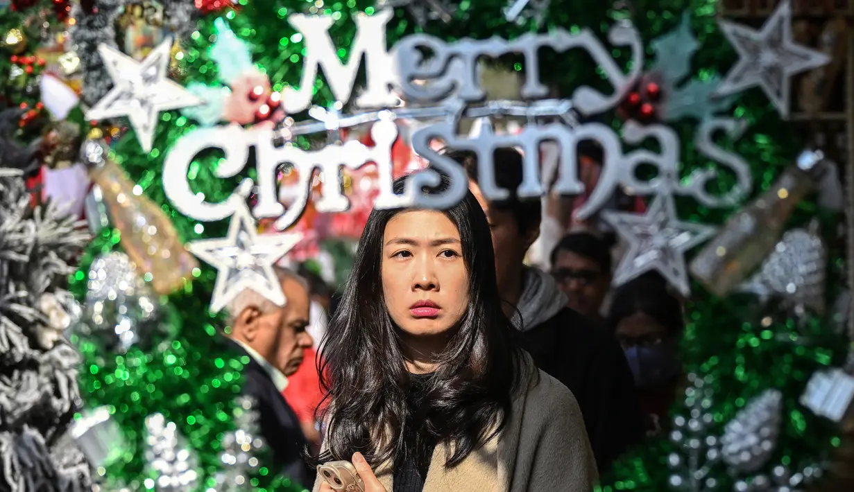 Pengunjung melintas di dekat barang-barang dekoratif yang dipajang di sebuah pasar menjelang perayaan Natal di New Delhi, India pada 13 Desember 2024. (Arun SANKAR/AFP)