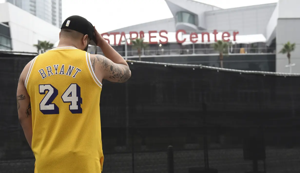 Gennesys Cabral, dari Los Angeles, mengenakan jersey Kobe Bryant di luar Staples Center, Los Angeles (26/1/2020). Selain Bryant, empat orang lainnya dalam helikopter itu juga dinyatakan meninggal dunia. (AP Photo/Chris Pizzello)