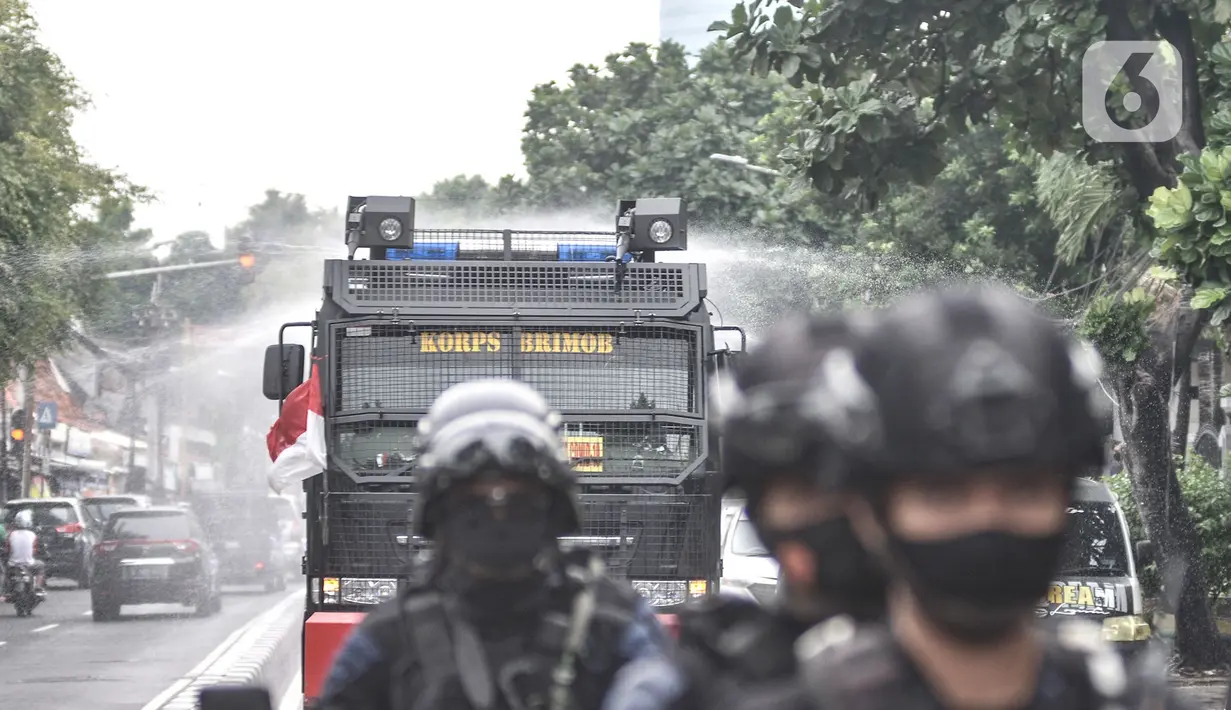 Petugas kepolisian menggunakan kendaraan meriam air saat menyemprotkan cairan disinfektan di Kawasan Petamburan, Jakarta, Minggu (22/11/2020). (merdeka.com/Iqbal S. Nugroho)