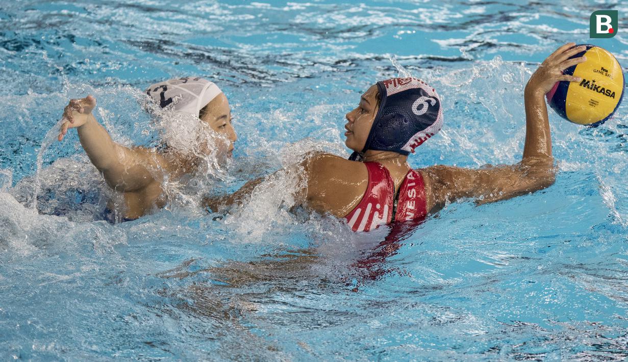 Pemain polo air putri Indonesia, Nyoman Ayu, mengamankan bola dari pemain polo air Jepang pada laga Asian Games di Aquatic Center, GBK, Jakarta, Kamis (16/8/2018). Jepang menang 15–4 atas Indonesia. (Bola.com/Vitalis Yogi Trisna)